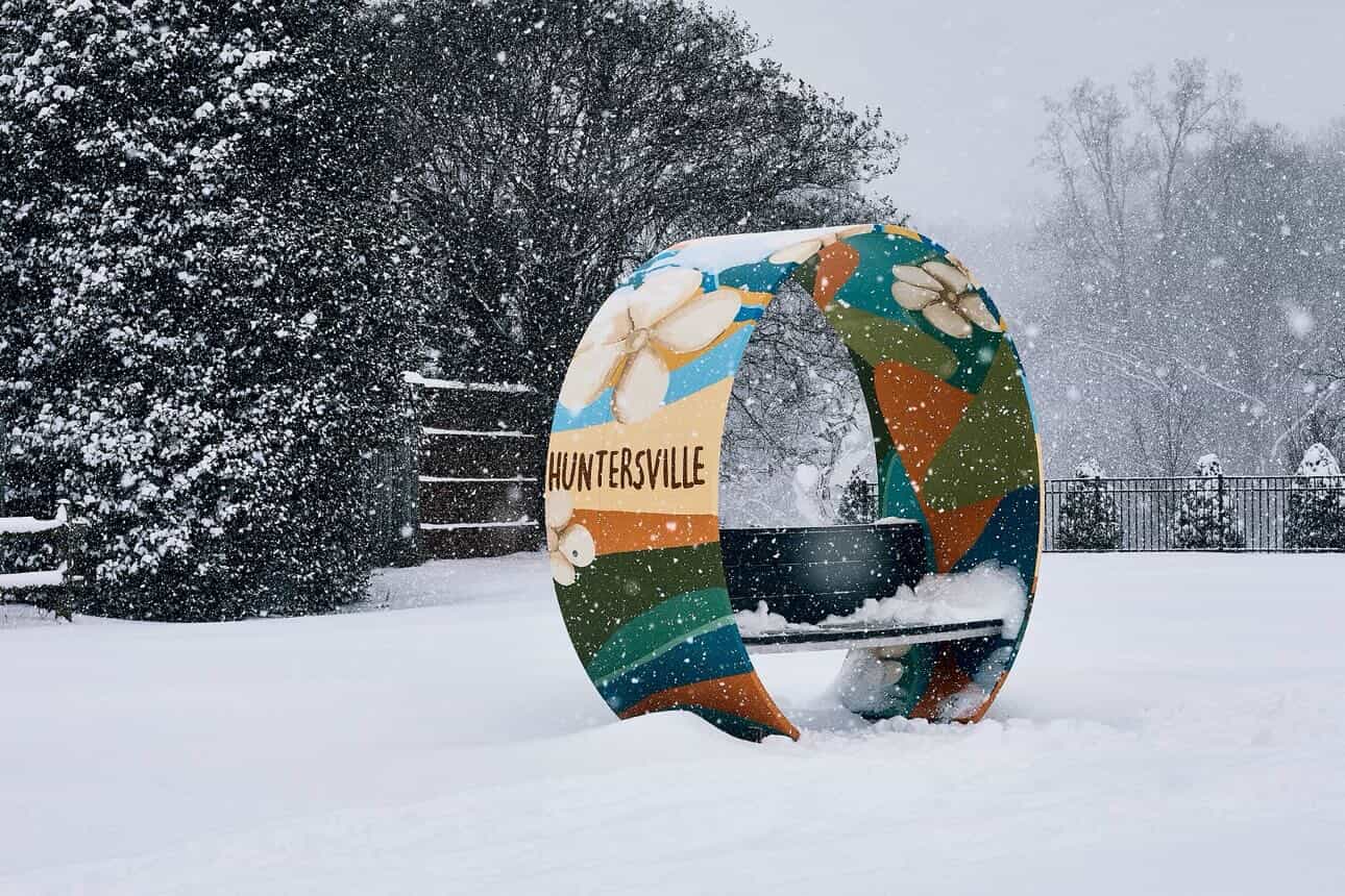 Colorful public art bench made from a repurposed wind turbine blade in snowy Huntersville, North Carolina, part of a Noblewins sustainable reuse project