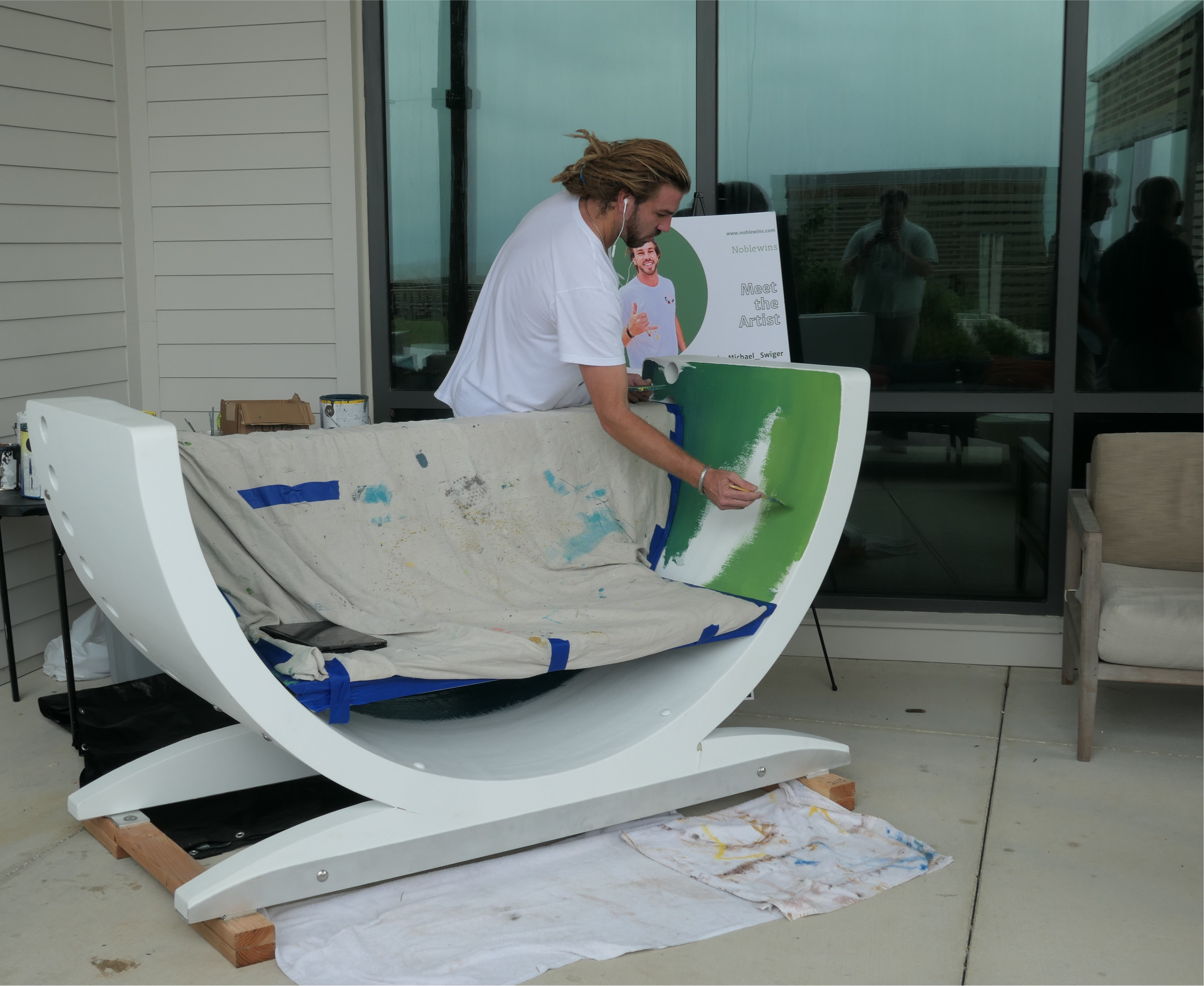 Artist painting a public art bench made from a repurposed wind turbine blade