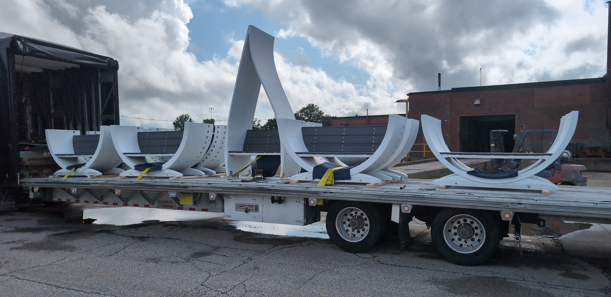 Public art benches made from repurposed wind turbine blades prepared for shipment on a flatbed truck by Noblewins